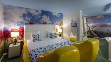 Experience a unique retreat with a large bed, vibrant wall mural, and cozy reading nook.