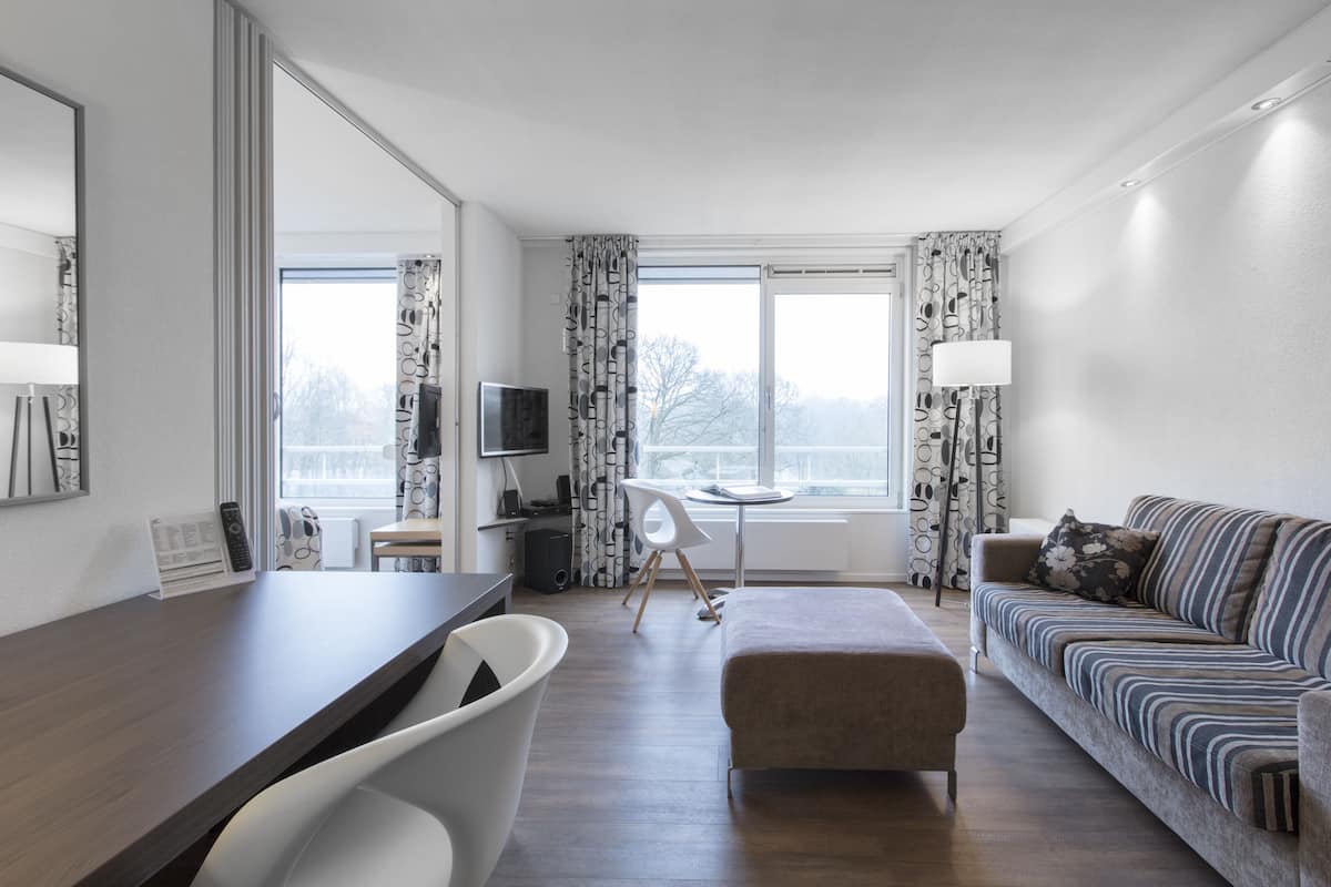 Suite – business | Oppholdsrom | En 55-tommers Flatskjerm-TV med kabel-kanaler samt strømmetjenester