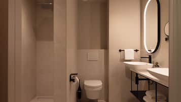 A modern bathroom with a shower, toilet, and dual sinks.