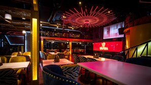A restaurant with zebra-patterned chairs, a red neon sign, and a modern chandelier. - Golden Parkk (Kolkata)