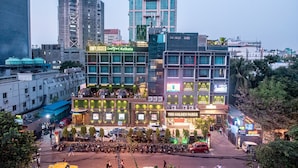 A hotel with multiple floors, outdoor seating area, and various signage including 'INPLUGGED' and 'THE GOLDEN PARKK'. - Golden Parkk (Kolkata)