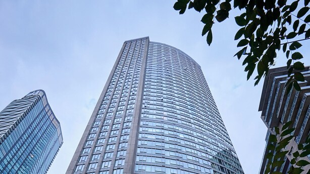 A modern hotel building with a glass facade and the name "PANTAGES HOTEL" displayed on the entrance.