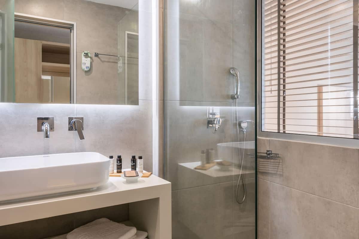 deluxe room, garden view | bathroom | combined shower/bathtub, hair dryer, bathrobes, slippers