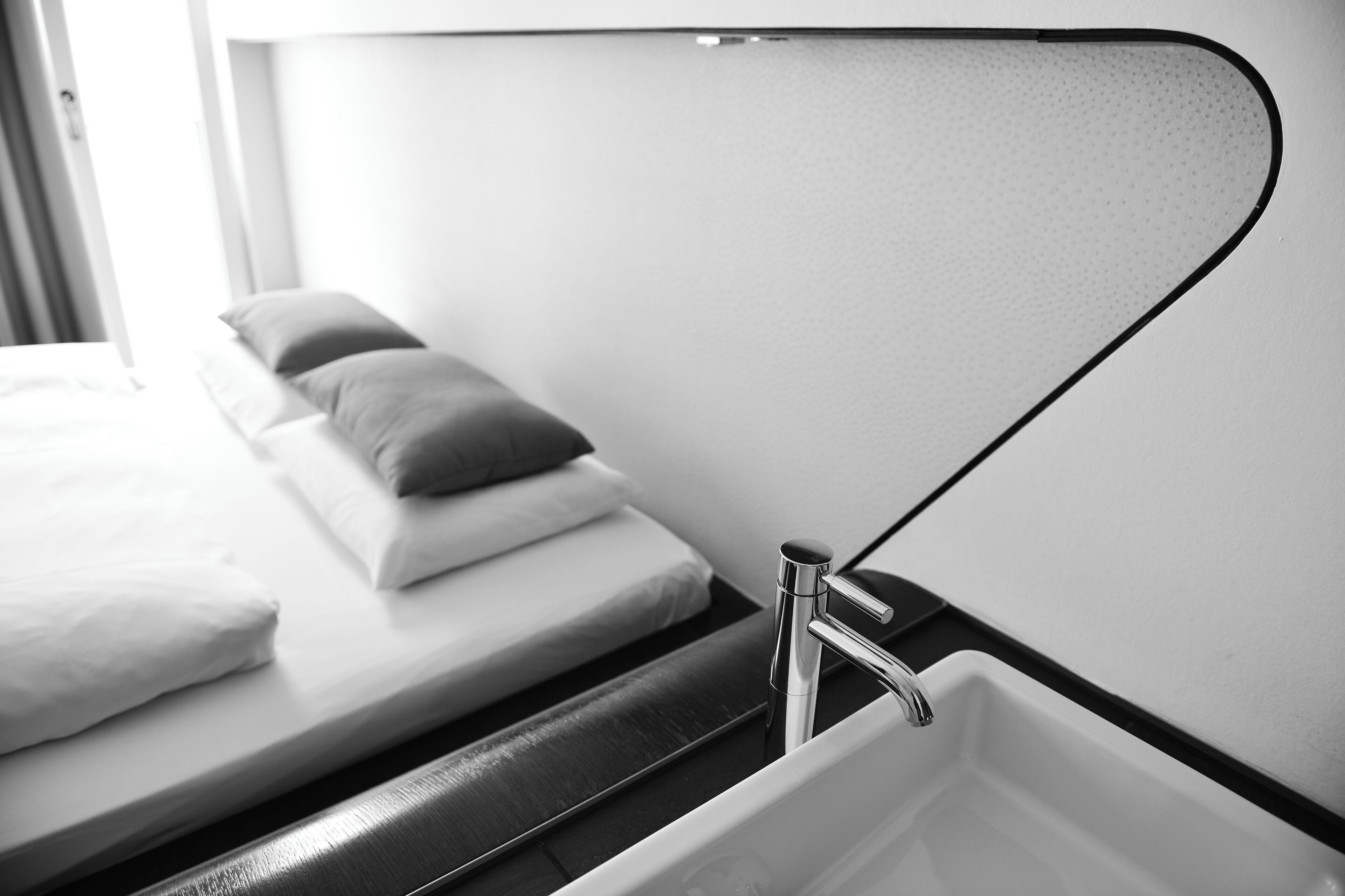 A modern bathroom with a large mirror, a sink, and a toilet.