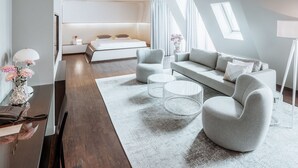 Une chambre moderne avec un lit superposé, un canapé, une table basse et un bureau avec une lampe et des fleurs.