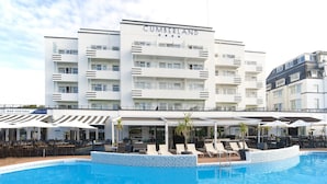 Un hôtel à plusieurs étages, nommé « CUMBERLAND », doté d’une piscine, d’un espace extérieur aménagé et d’un bar appelé « BAR VENTANA ».