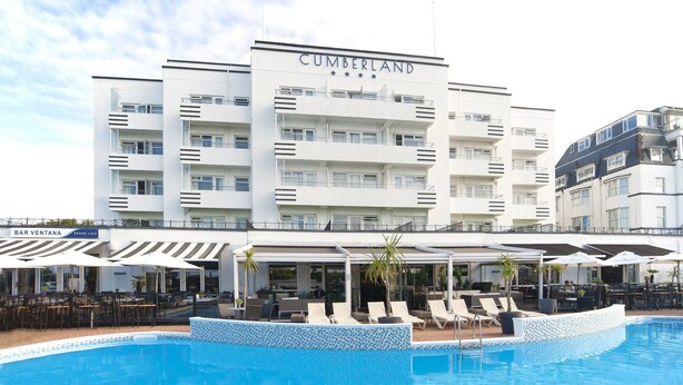 Un hôtel à plusieurs étages, nommé « CUMBERLAND », doté d’une piscine, d’un espace extérieur aménagé et d’un bar appelé « BAR VENTANA ».