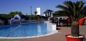 Piscine extérieure, parasols de plage, chaises longues