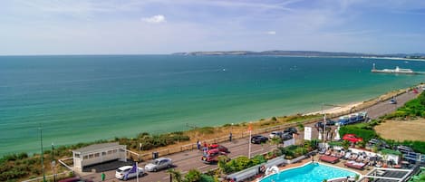 Alberca techada, alberca al aire libre y sombrillas en la alberca