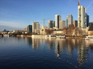 Ein Fluss mit einem Boot und einer Stadtansicht im Hintergrund.