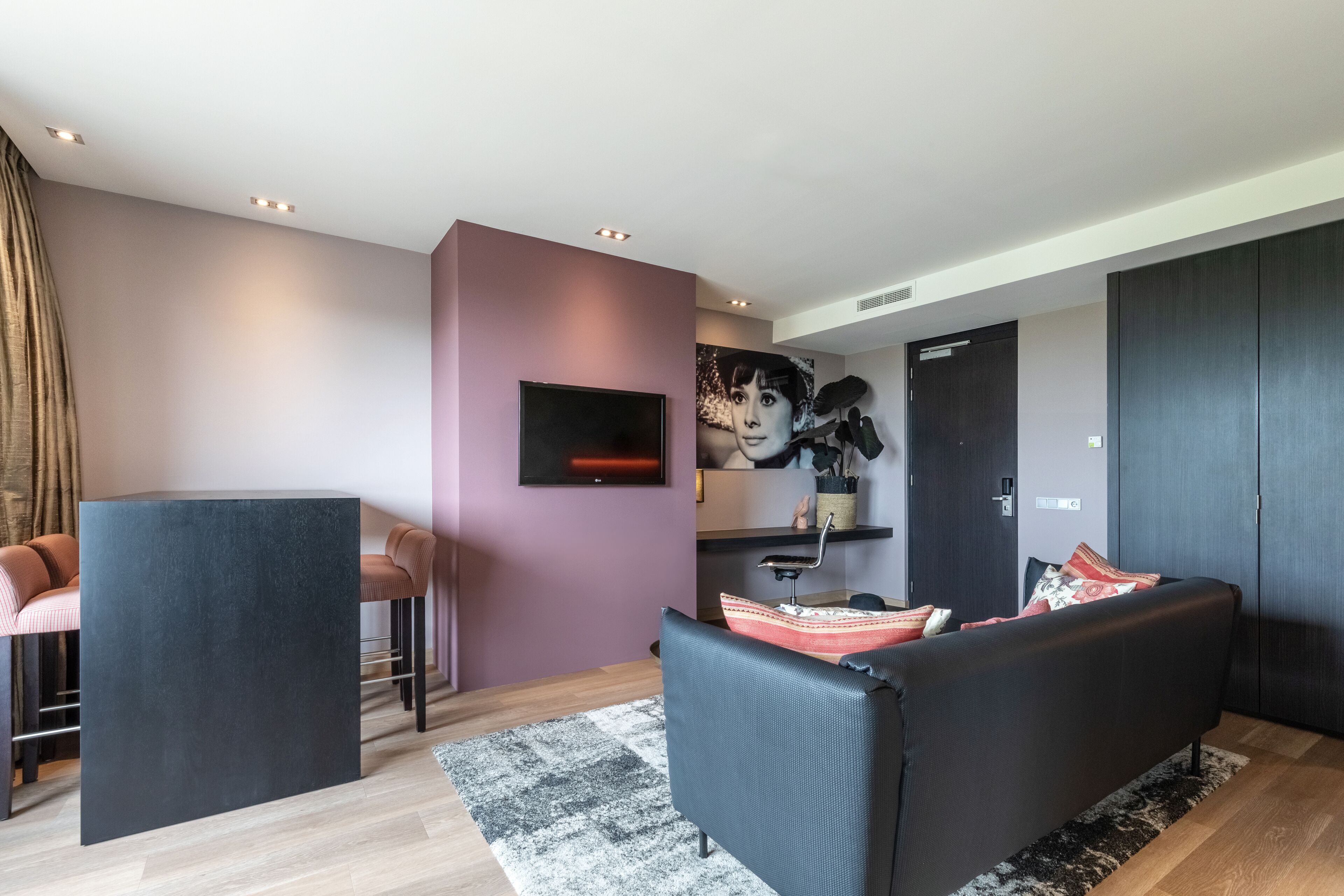 Un salon moderne avec un canapé, une table basse et un téléviseur fixé au mur.