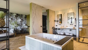 Un baño moderno con una bañera grande, un tocador con espejo y una zona de ducha.