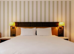 A hotel room with a large bed, two bedside lamps, and a striped wall. -  Peppers Clear Mountain (Cashmere)