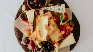 A charcuterie board with various cheeses, fruits, and olives.