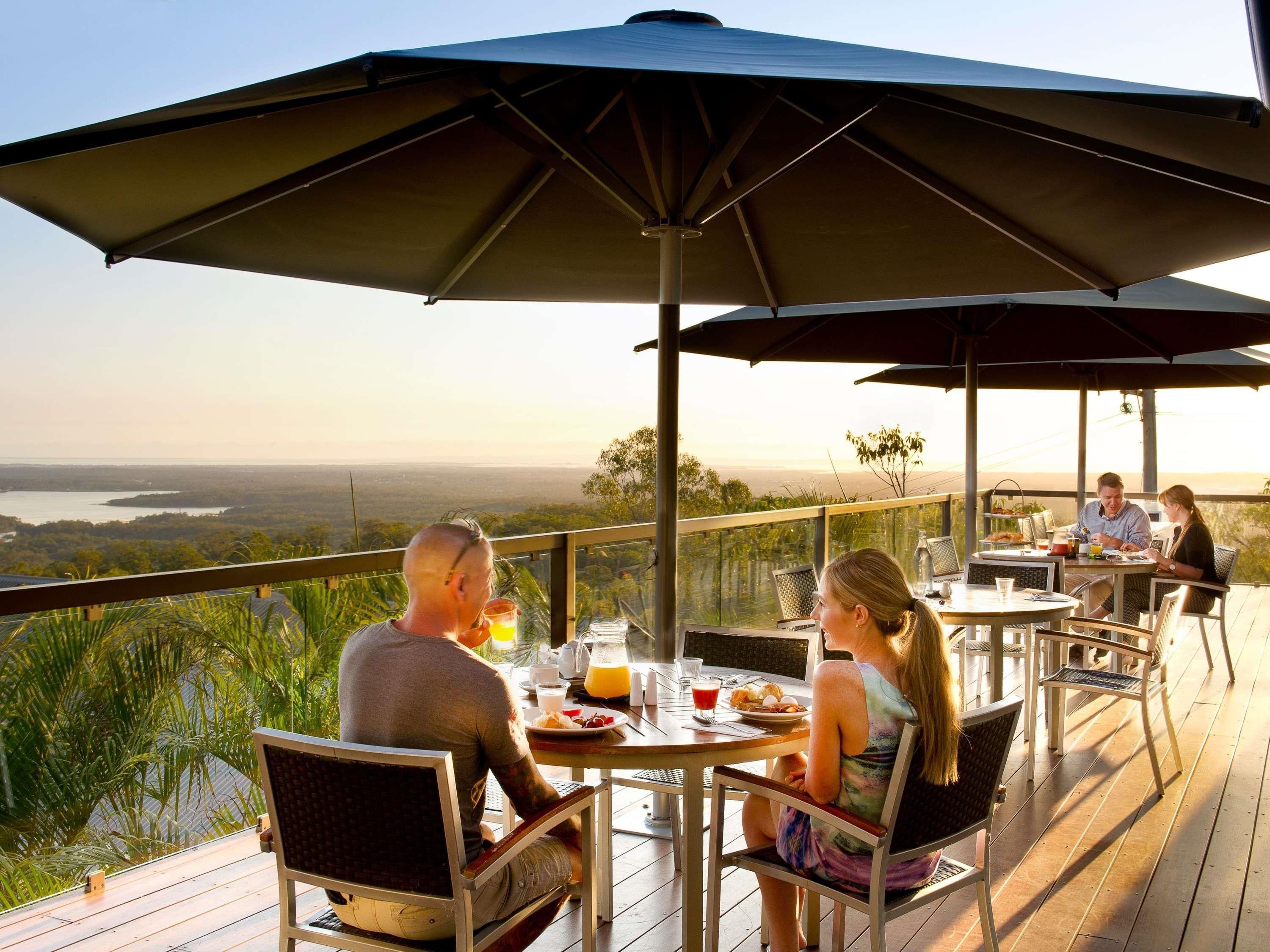 A terrace with outdoor seating, overlooking a scenic landscape.
