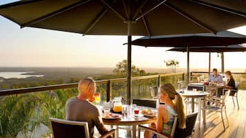 A terrace with outdoor seating, overlooking a scenic landscape.
