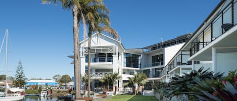 A modern building with a marina, including boats and a dock.