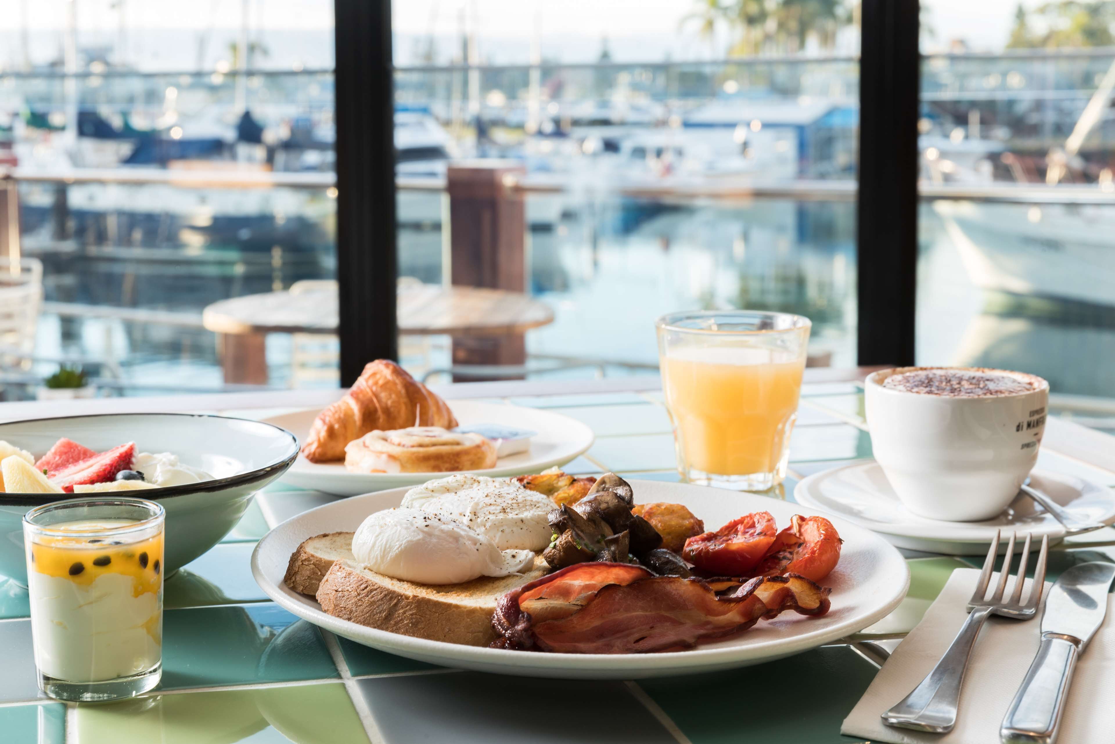 Ein Frühstückstisch mit Blick auf Boote und einen Hafen.