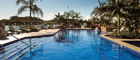 Una piscina al aire libre, sillones reclinables de piscina