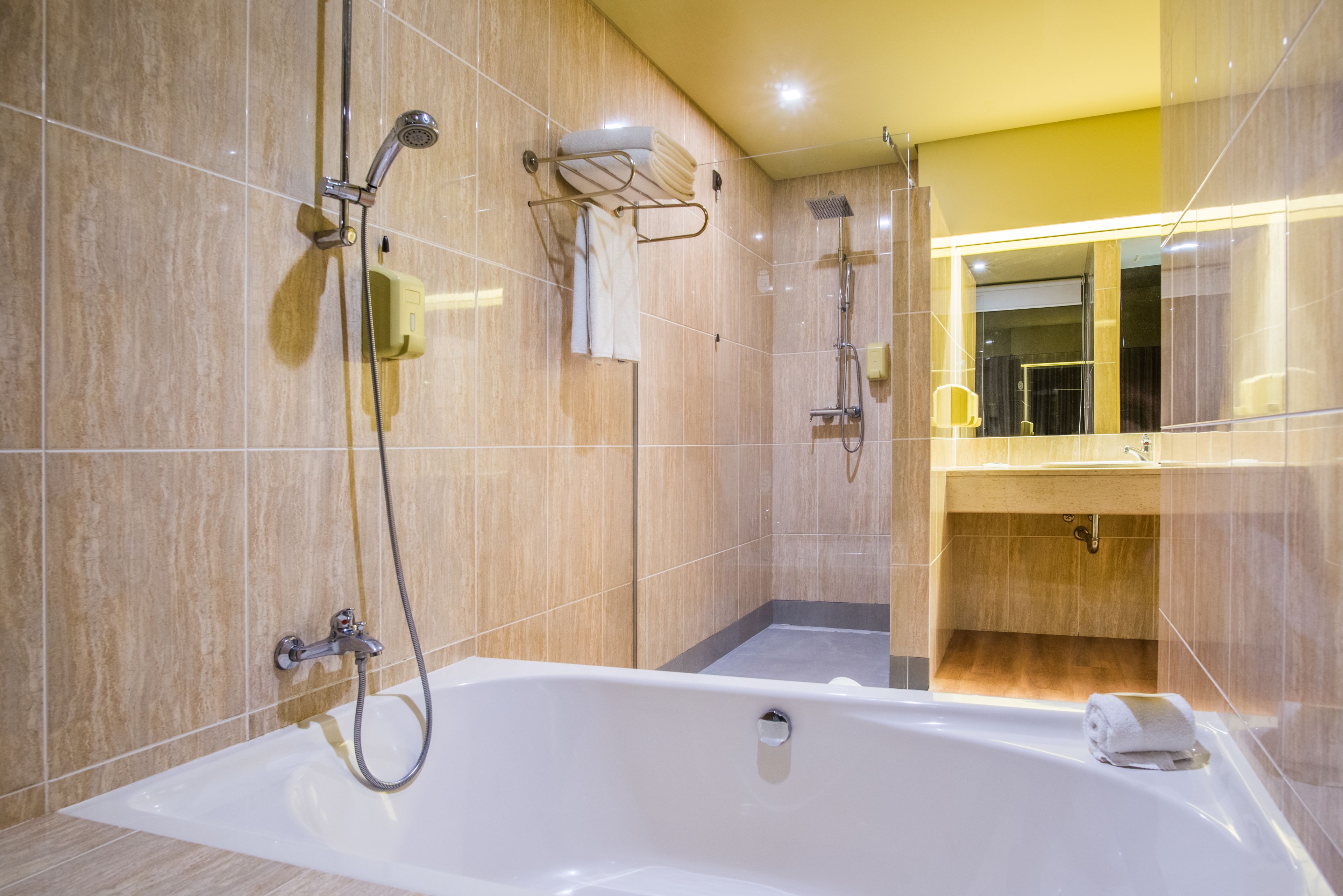 Une salle de bain moderne équipée d’une baignoire, d’une douche et d’un meuble-lavabo avec un miroir.