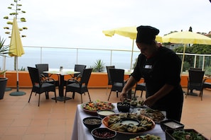 A chef preparing food at an outdoor dining area with a view of the sea. - Hotel Alpino Atlantico Ayurveda Cure Centre - Adults Only (Santa Cruz)