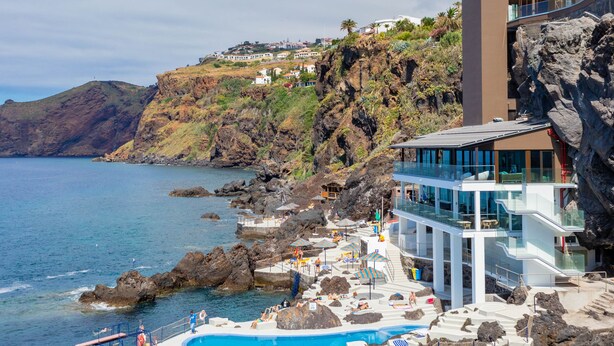 A coastal hotel with a pool, a lifeguard stand, and a rocky shoreline. - Hotel Alpino Atlantico Ayurveda Cure Centre - Adults Only (Santa Cruz)