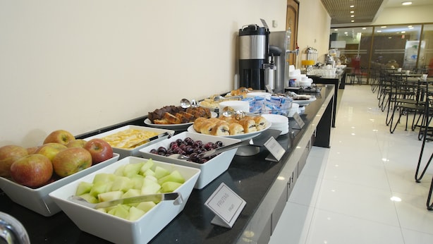 A buffet with various food items including fruits, pastries, and beverages. - Diego De Almagro Santiago Centro (Santiago)