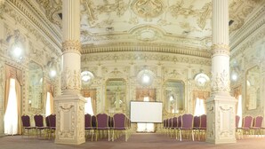 A grand hall with ornate columns, a large screen, and rows of purple chairs. - Diego De Almagro Santiago Centro (Santiago)