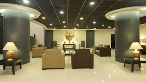 A lobby with sofas, armchairs, and tables, featuring a central coffee table and two lamps on either side. - Diego De Almagro Santiago Centro (Santiago)