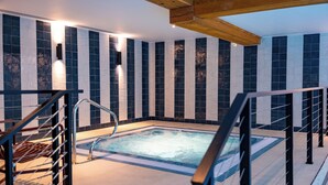 A modern indoor swimming pool with a wooden ceiling and tiled walls. - Solent Hotel and Spa (Fareham)