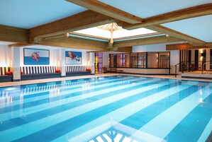 Una piscina techada, sillones reclinables de piscina