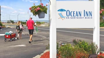Une enseigne indiquant l’emplacement de l’hôtel Ocean Inn, sur la plage de Nantasket, avec une vue dégagée sur la plage et l’océan en arrière-plan.