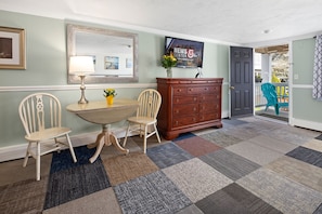 Enter a stylish space with a light green wall, a large mirror, and a dining table for two.