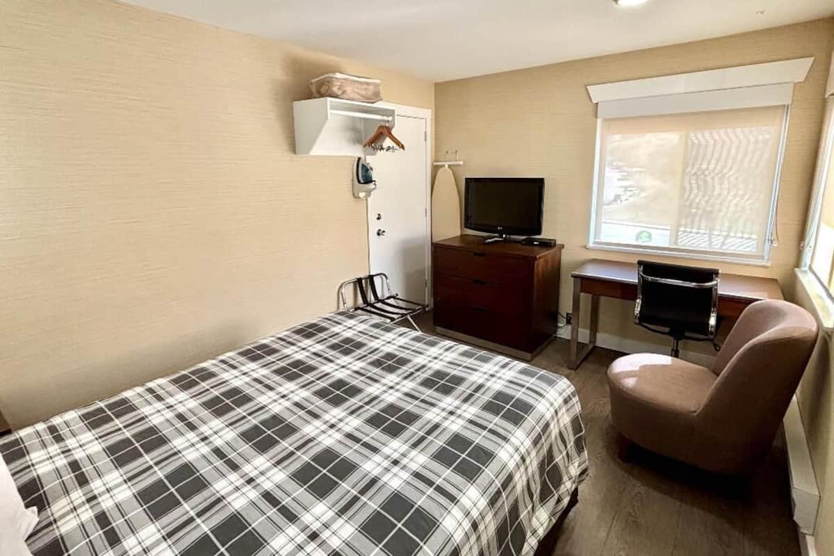 Premium bedding, desk, laptop workspace, blackout drapes