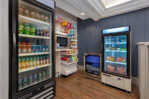 Diversos distribuïdors refrigerats de begudes i opcions de menjar a un magatzem.