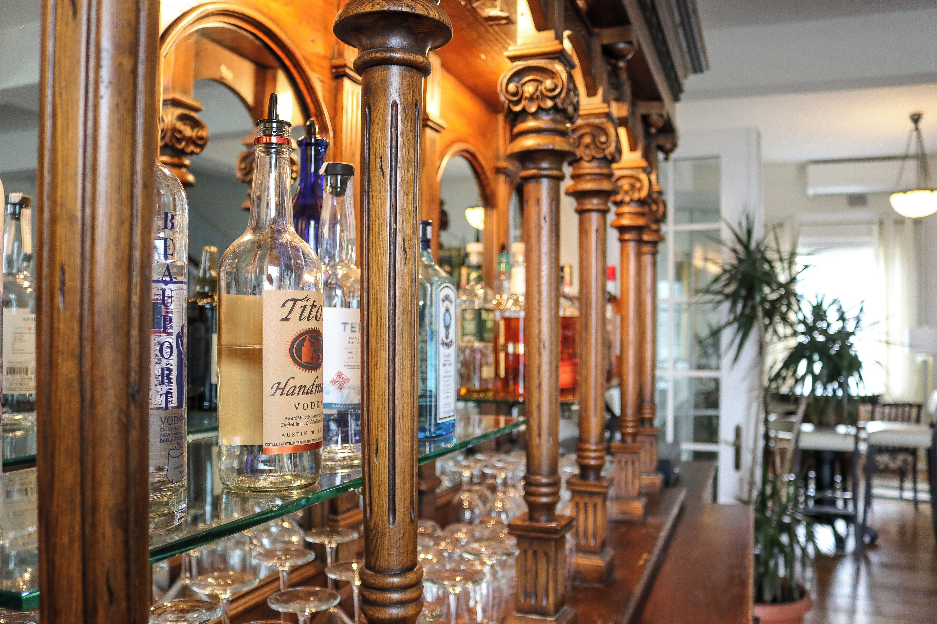 A bar area with shelves of liquor bottles and glasses.