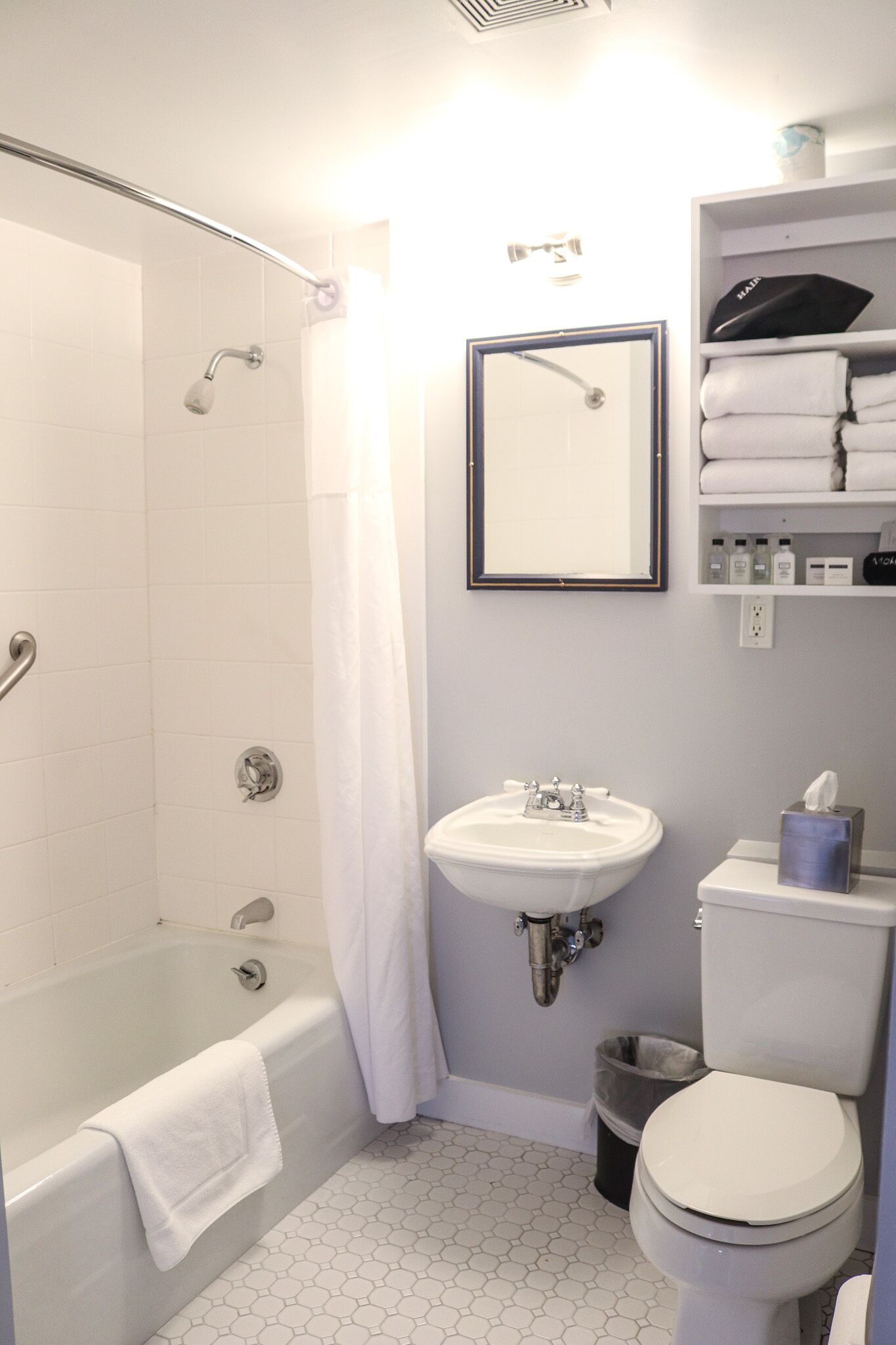 A bathroom with a bathtub, sink, toilet, and a mirror.