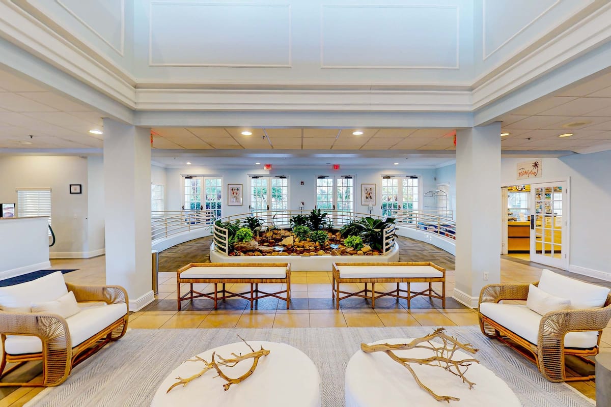 A spacious lobby with a central water feature, seating areas, and a view of the outdoor area.