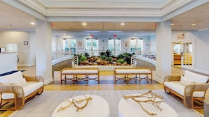 A spacious lobby with a central water feature, seating areas, and a view of the outside. - Bahama Bay Resort (Davenport)