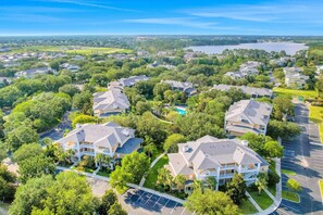 A residential area with multiple houses, a swimming pool, and a lake in the background. - Bahama Bay Resort (Davenport)