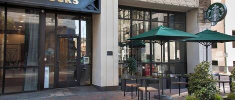 A Starbucks with outdoor seating and a brick facade.
