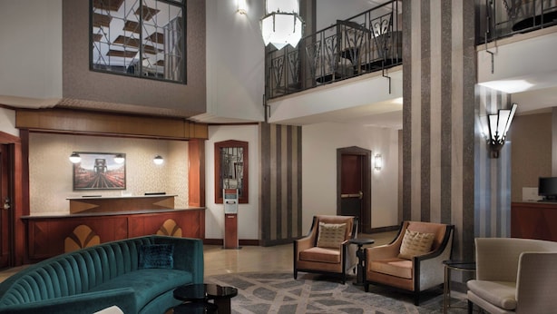 A spacious lobby with a high ceiling, a mezzanine level, and a seating area with sofas and armchairs. - Residence Inn by Marriott Memphis Downtown (Memphis)