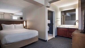 A hotel room with a large bed, a bathroom with a mirror, and a small desk. - Residence Inn by Marriott Memphis Downtown (Memphis)