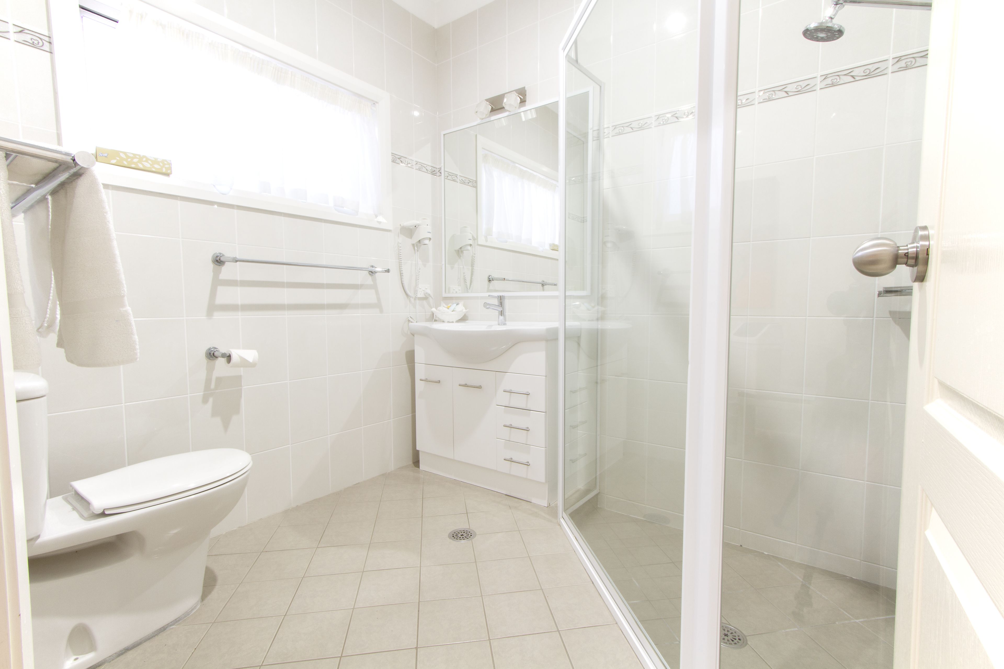 A bathroom with a toilet, sink, and shower.
