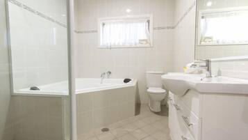 Un baño con bañera, inodoro y lavamanos.