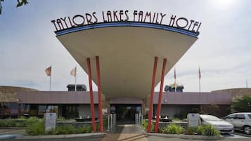 De ingang van het Taylors Lakes Family Hotel, herkenbaar aan het opvallende gebogen dak en rode pilaren.
