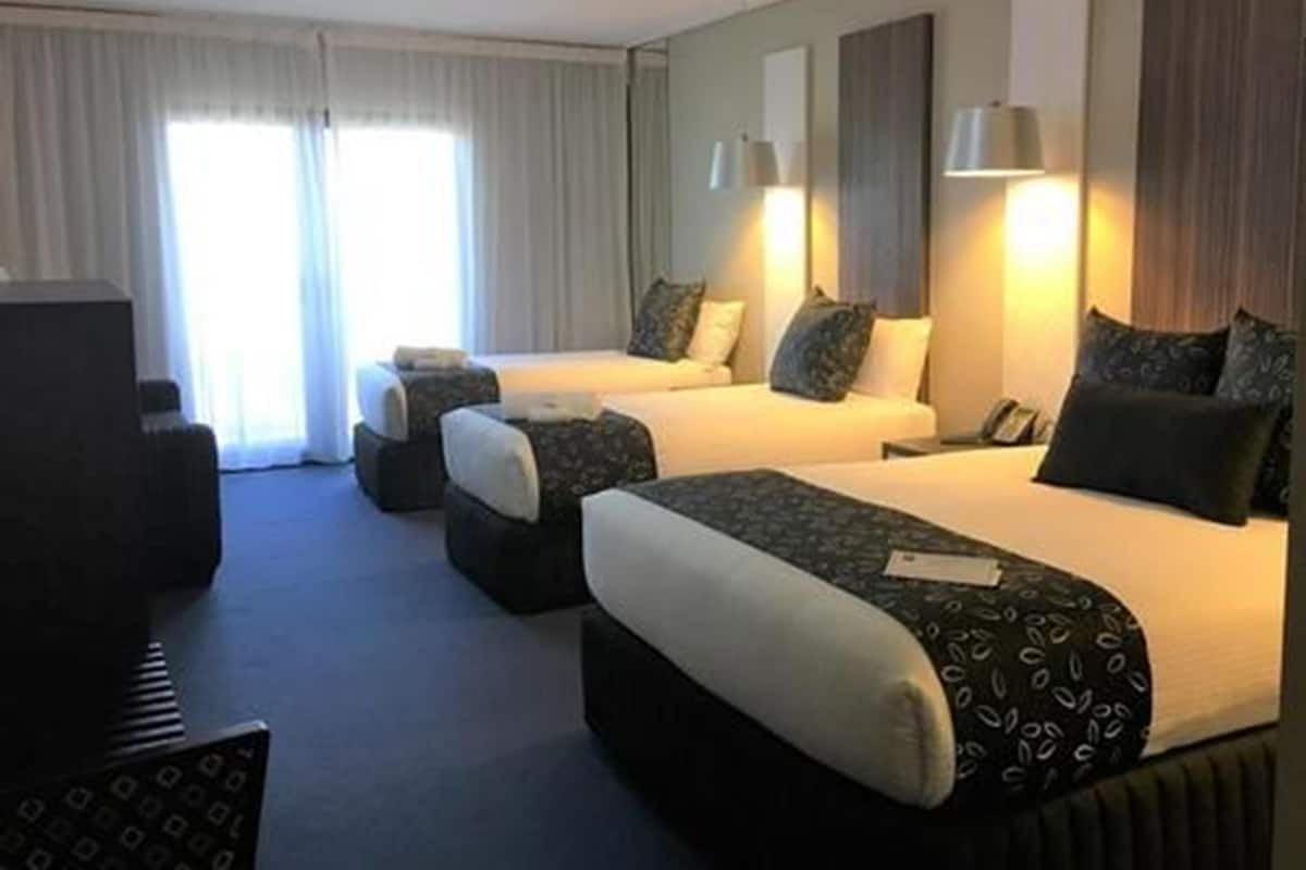 Una habitación de hotel con dos camas, televisión y escritorio.