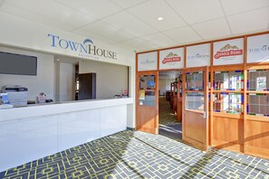 Zona de recepción con el letrero TownHouse, un mostrador de recepción y una barra James Boag.