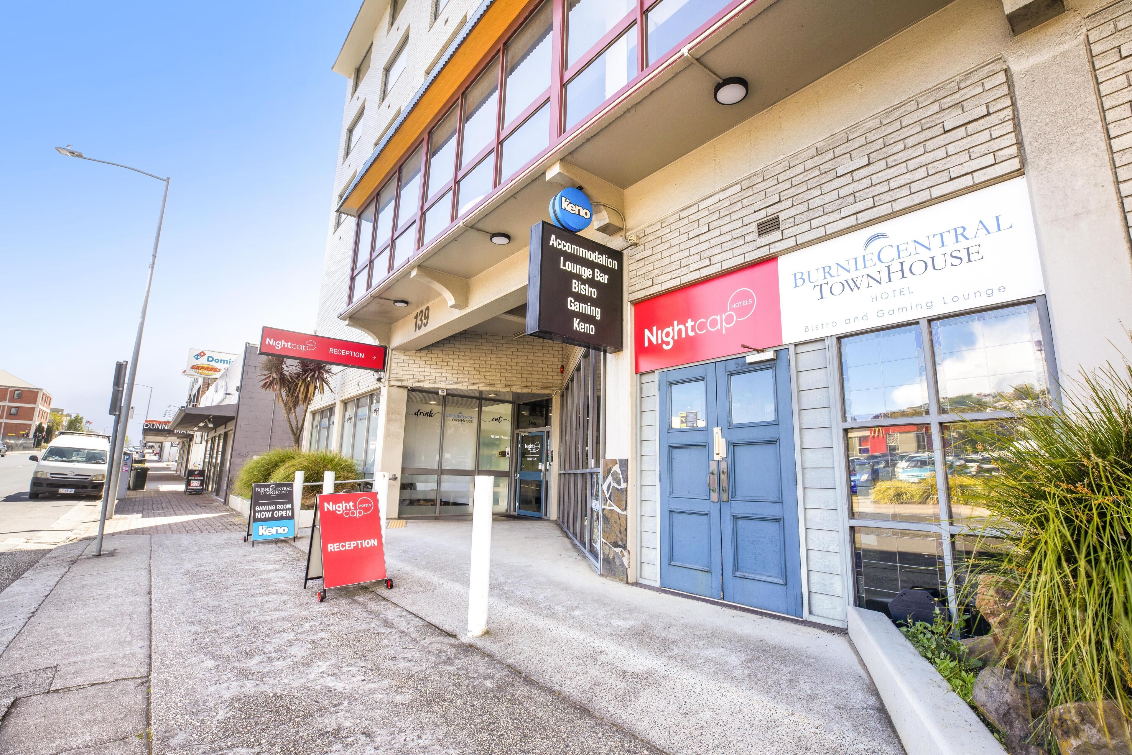 L’entrée d’un hôtel, avec des panneaux indiquant « Burnie Central Townhouse », « Nightcap Reception » et un panneau « Keno ».