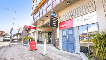 L’entrée d’un hôtel, avec des panneaux indiquant « Burnie Central Townhouse », « Nightcap Reception » et un panneau « Keno ».